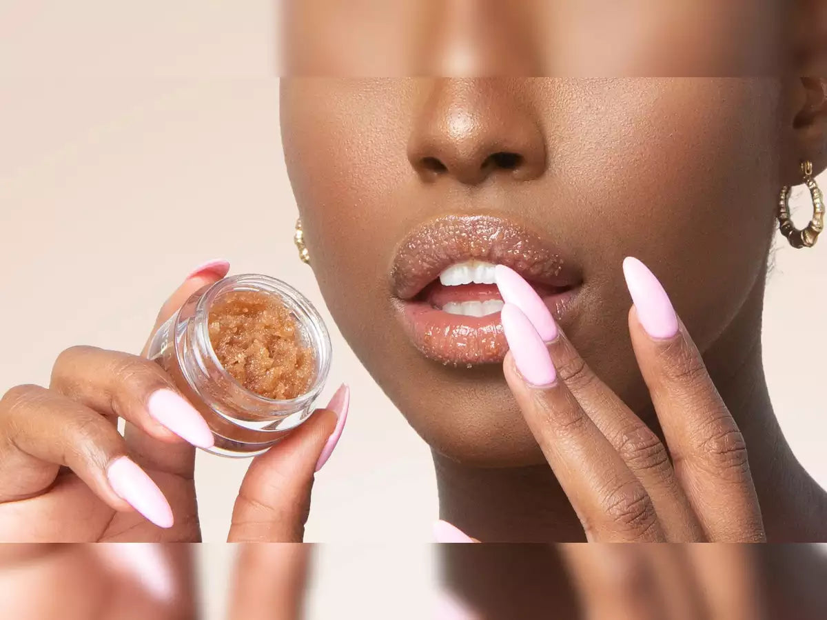 black woman exfoliates her lips with a sugar kiss lip scrub